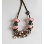 A Pandora white metal necklace with thirteen various charms, including pink and glass and cultured