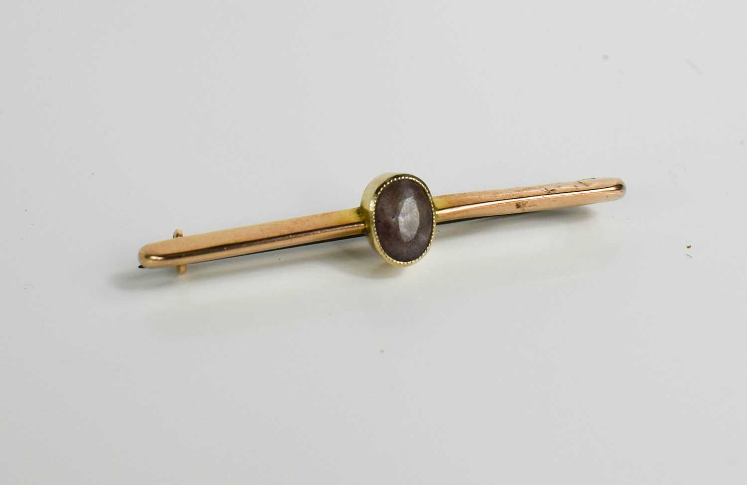 A 9ct gold and amethyst bar brooch, with steel pin, 2.65g.