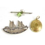 A brooch in the form of boats, a spider bar brooch and a photo locket pendant.