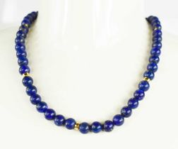 An 18ct gold and lapiz lazuli beaded necklace, with 18ct gold and paste clasp, 47g, 92cm long.