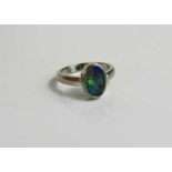 An 18ct white gold and black opal ring, the oval opal approx 11mm by 7mm, size M, 5.1g.