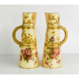 A pair of Royal Worcester jugs, the peach ground painted with flowers and gilt bamboo handles,