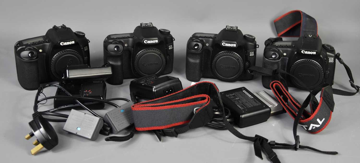 Four Canon digital camera bodys, 20d, 30d and two 40d examples, with batteries and chargers.
