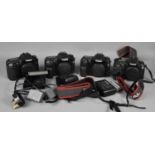 Four Canon digital camera bodys, 20d, 30d and two 40d examples, with batteries and chargers.