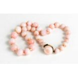 A pink stone beaded necklace, likely angel coral, with 9ct gold clasp, 59g.