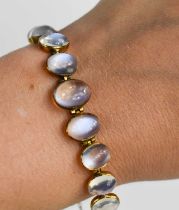 A Victorian moonstone and gold bracelet (testing as 9ct), graduated cabochon moonstones, 7.5g.