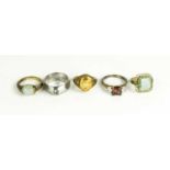A group of five gem set rings, some silver, and including one modern steel solitaire example.