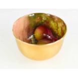 A Royal Worcester bowl by E Townsend, painted inside with fruit to a mossy ground, with gilded