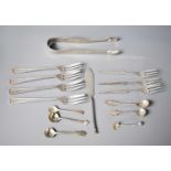 A pair of silver sugar nips together with a group of silver salt spoons and fish forks, all