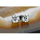 A pair of diamond solitaire earrings, set in platinum with alpha back secure fittings, each