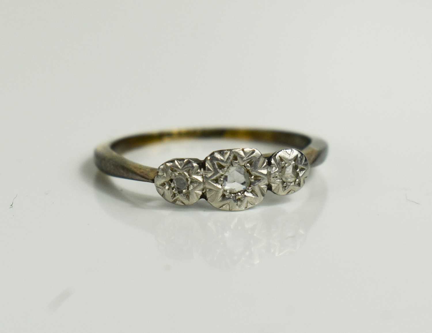 A platinum and 9ct gold ring, with three chip diamonds in illusion setting, size J, 1.6g. - Bild 2 aus 3