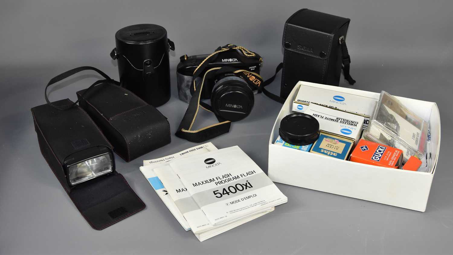 A Minolta 35mm SLR camera with extra lenses and flashes.