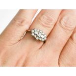 A platinum and diamond cluster ring, by Dawson of Stamford, the three baguette cut diamonds to the