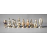 A group of silver salt and peppers to include a pair and a small silver bud vase, one example with a