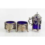 A pair of Dutch silver salts with blue glass liners, the silver cases having pierced floral scroll