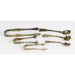 A group of silver to include three pairs of sugar tongs, and three sauce spoons, 3.43toz total.