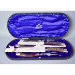 A silver collared stag antler handled carving set by Mappin & Webb, comprising two knives, two forks