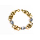 An 18ct gold [tested as] and aquamarine chain link bracelet, with three oval aquamarines, 17.55g.