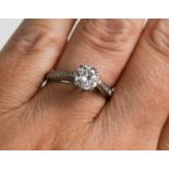 An 18ct white gold and diamond ring, the central round brilliant cut diamond approximately 1.01ct,