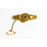 A Victorian 9ct gold brooch with central set ruby surrounded by diamonds, 2.8g