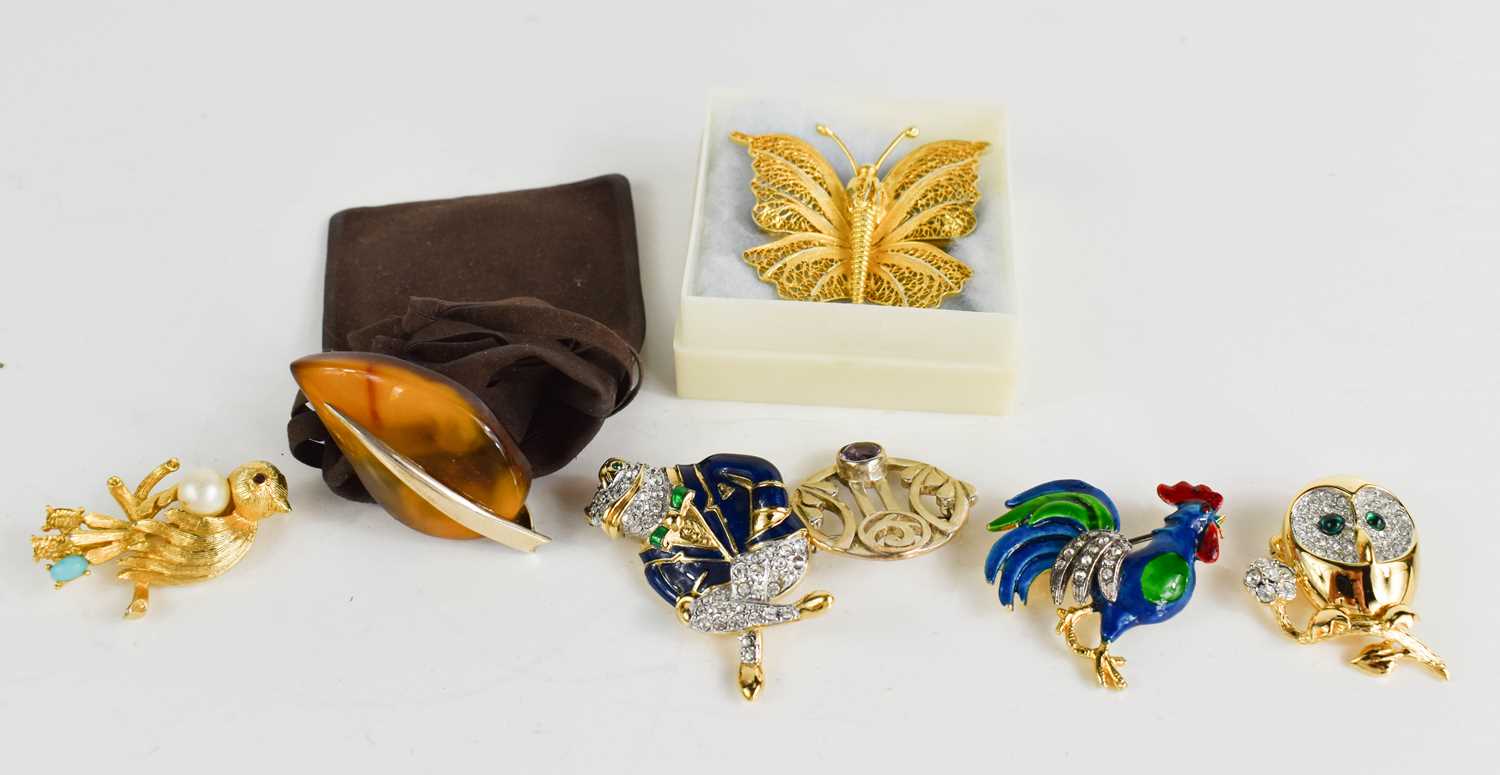 Seven various brooches, including a butterfly filagree example, an enamel and paste cockerel, a