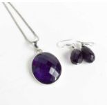 An amethyst oval pendant set in silver, with silver chain, and matching drop earrings.