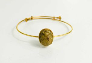 A 14ct gold Egyptian bangle, with a stone carved scarab beetle, and enamelled sliding ends, 8.6g