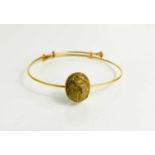 A 14ct gold Egyptian bangle, with a stone carved scarab beetle, and enamelled sliding ends, 8.6g