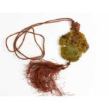 A Chinese jade carved pendant, with pierced and carved decoration, and red tassel.