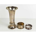 A silver trumpet form vase with weighted base together with two silver napkin rings.