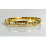 An 18ct gold and diamond bangle, set with eight brilliant cut diamonds, each approximately ¼ct,
