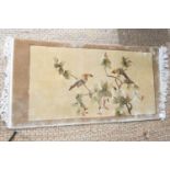 A Chinese style small rug, decorated with birds amongst prunus branches, 60 by 124cm plus fringe.