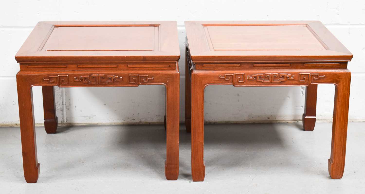 A pair of Chinese hardwood tables with square tops and caned decoration, 60cm by 60cm by 25cm.