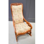 An American rocking chair with carved leaf and flower design to the top.