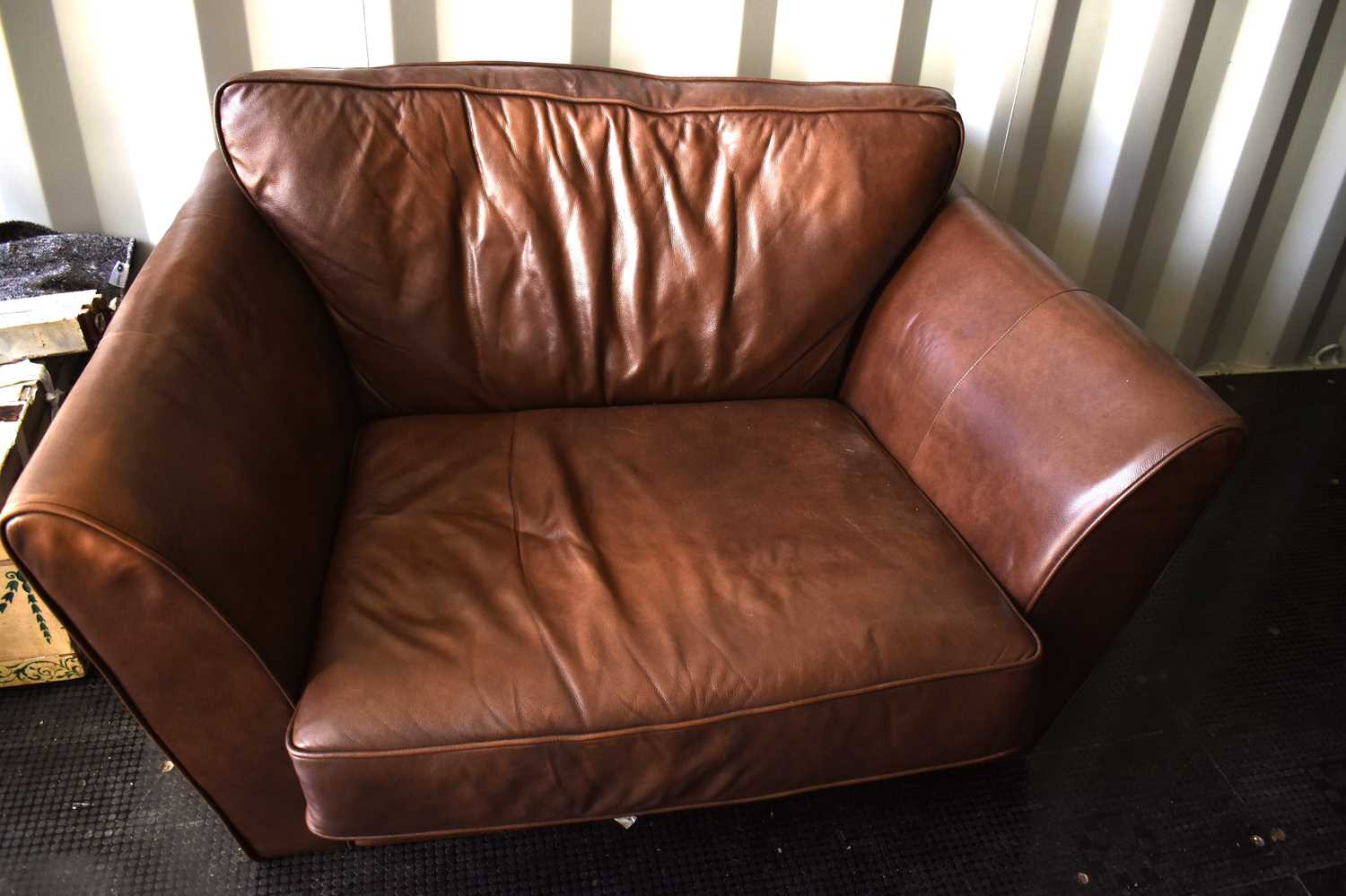 A John Lewis brown leather snuggler armchair.