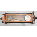 A mahogany cased Vienna wall clock with enamel dial and Roman numerals.