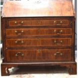 A George III walnut bureau, the fall front enclosing mahogany and satinwood crossbanding interior of