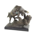 A bronzed sculpture of a bison and bear fighting raised on a metal base, 23cm high.
