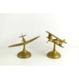 Two brass desk models of a Spitfire and Biplane, 15cm high.