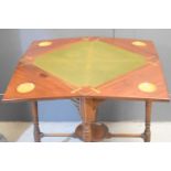 A 19th century mahogany games table, the top opening with four triangular flaps, 73cm high by 54cm