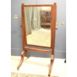 A 19th century mahogany cheval mirror, the reeded frame flanked by candle holders.