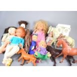 A group of vintage dolls, rag dolls, large plastic horses and clothing to include a Palitoy large
