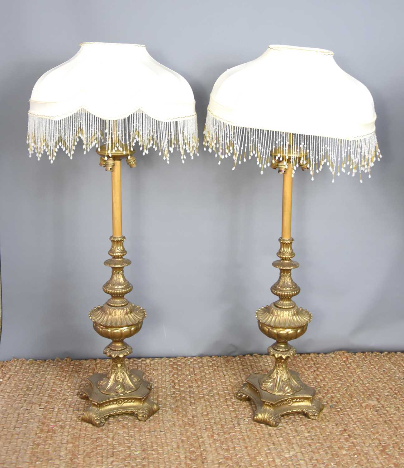 A pair of 19th century brass standard lamps, , converted to electric with cream silk shade and