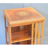 An Edwardian mahogany inlaid revolving bookcase with various sections for books.