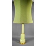 A large Mid Century table lamp, with green glass base, and green shade, 106cm high to top of shade.