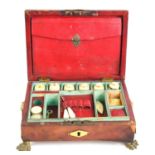 A Regency red leather clad sewing box of sarcophagus form, lion head ringed handles with monogrammed
