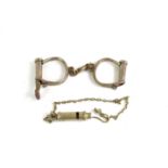 A set of Hiatt best wrought iron handcuffs with key together with a Metropolitan whsitle.