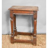A 17th century oak joint stool with moulded plank top above baluster turned legs united by