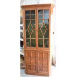 An oak gun display cabinet, with glazed upper section, and panelled door below.