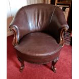 A 20th century antique style leather and mahogany tub chair.
